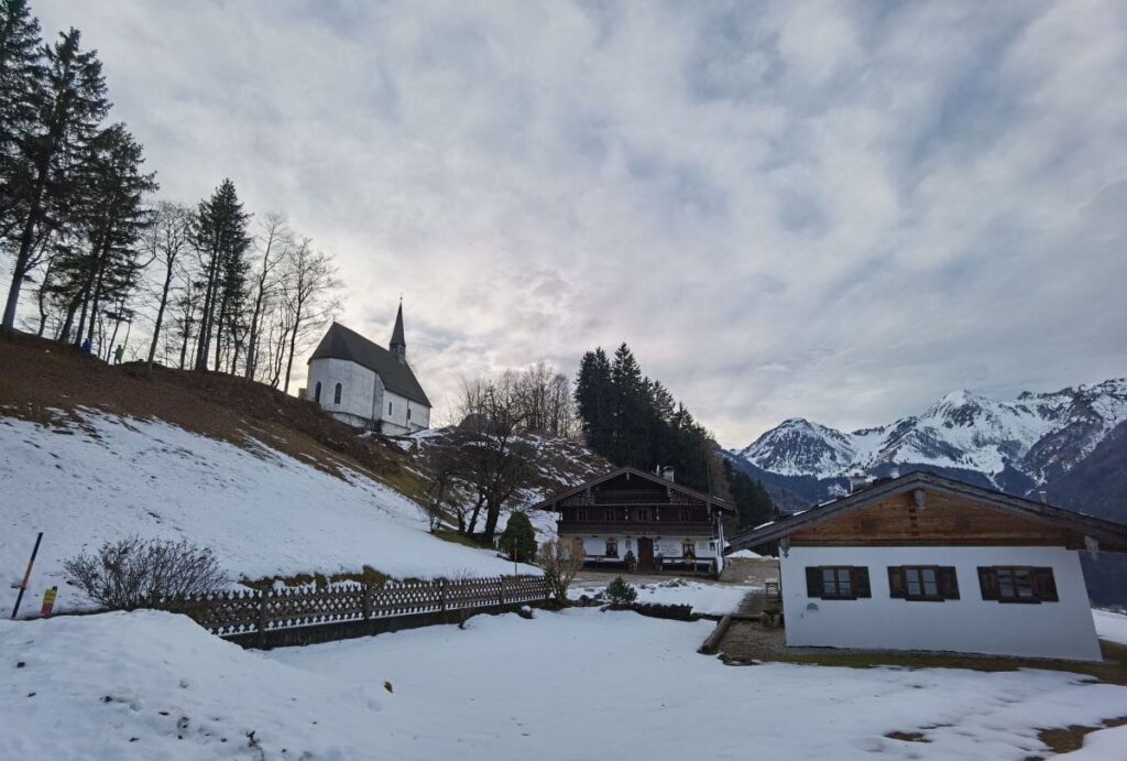 Streichenkirche Schleching - mit dem ehemaligen Mesnerhaus und dem Blick auf die Chiemgauer Alpen